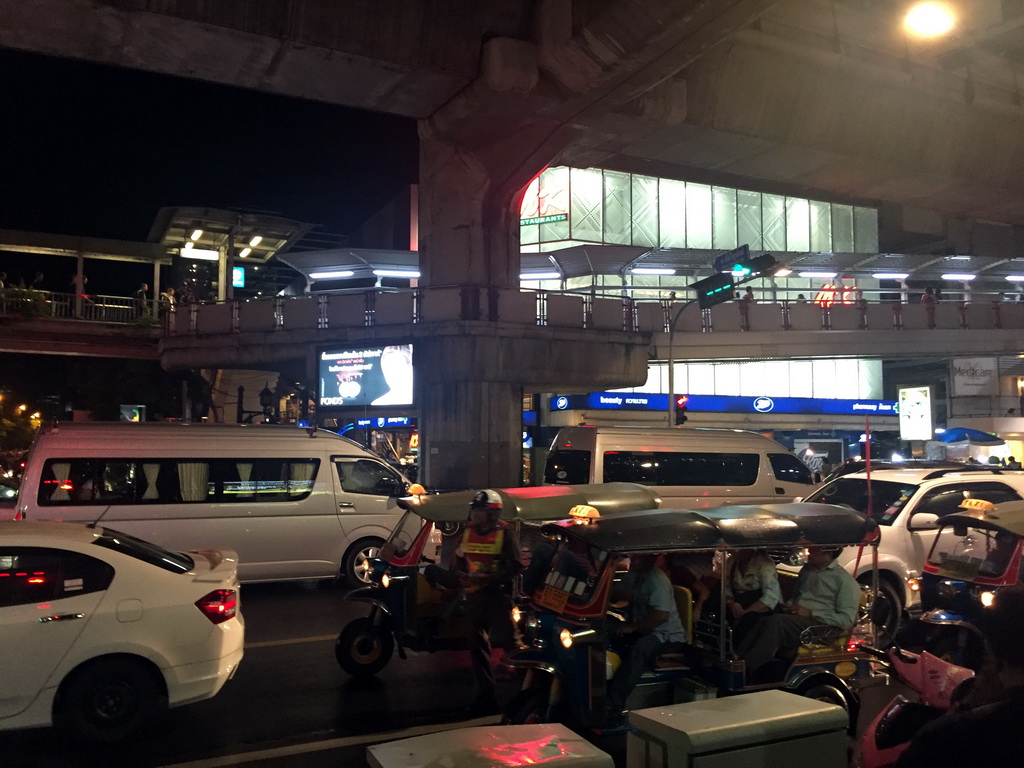 Rickshaws, cars and skywalk at Cha Loem Pao Junction, by night
