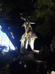 Dolphins statue at the southeast side of the Central World shopping mall at Rama I Road, by night