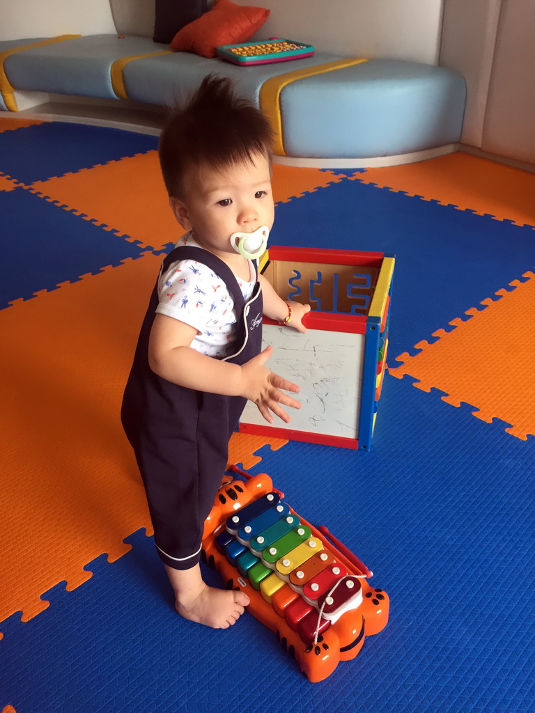 Max with a box and xylophone in the Play Room of the Grande Centre Point Hotel Ratchadamri Bangkok