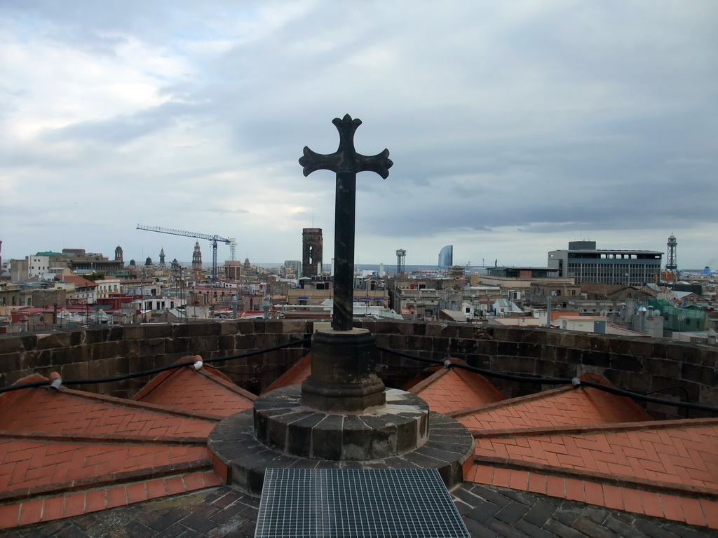Cross at the roof of the Cathedral of Santa Eulalia, with a view on the region to the southeast, with the tower of the Basílica dels Sants Màrtirs Just i Pastor church, the W Barcelona building (Hotel Vela) and the Torre Jaume I tower