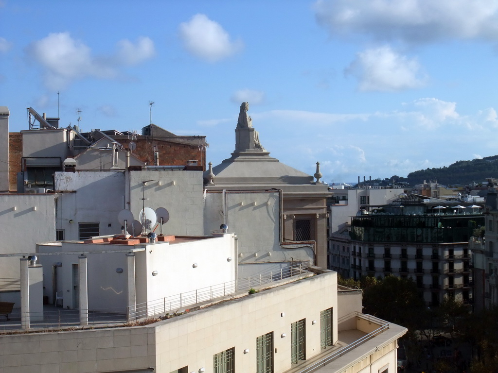 Statue on top of a building at the Passeig de Gràcia street, viewed from the roof of the La Pedrera building