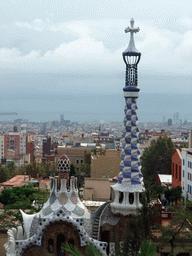 The tower of the west entrance building of Park Güell, with a view on the city center