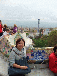 Miaomiao at the Square of Nature at Park Güell, with a view on the tower of the west entrance building and the city center