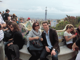 Tim and Miaomiao at the Square of Nature at Park Güell, with a view on the tower of the west entrance building and the city center