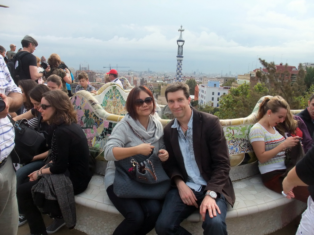 Tim and Miaomiao at the Square of Nature at Park Güell, with a view on the tower of the west entrance building and the city center