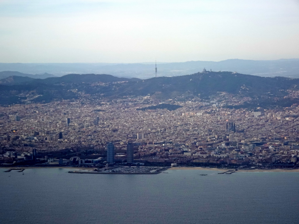 The city center with the Port Olímpic harbour, the Sagrada Família church and the Tibidabo mountain with the Sagrat Cor church, viewed from the airplane from Amsterdam