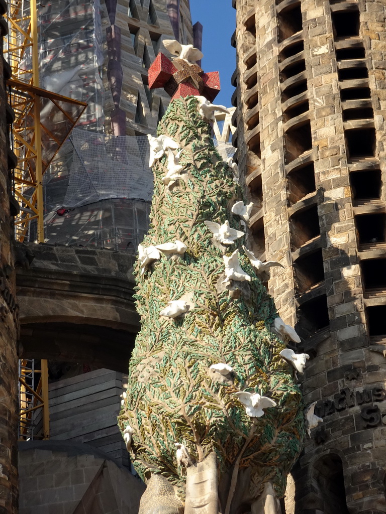 Statue of a tree with doves at the Nativity Facade at the northeast side of the Sagrada Família church, viewed from the Carrer de la Marina street