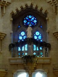 Statue and stained glass windows at the northeast transept of the Sagrada Família church