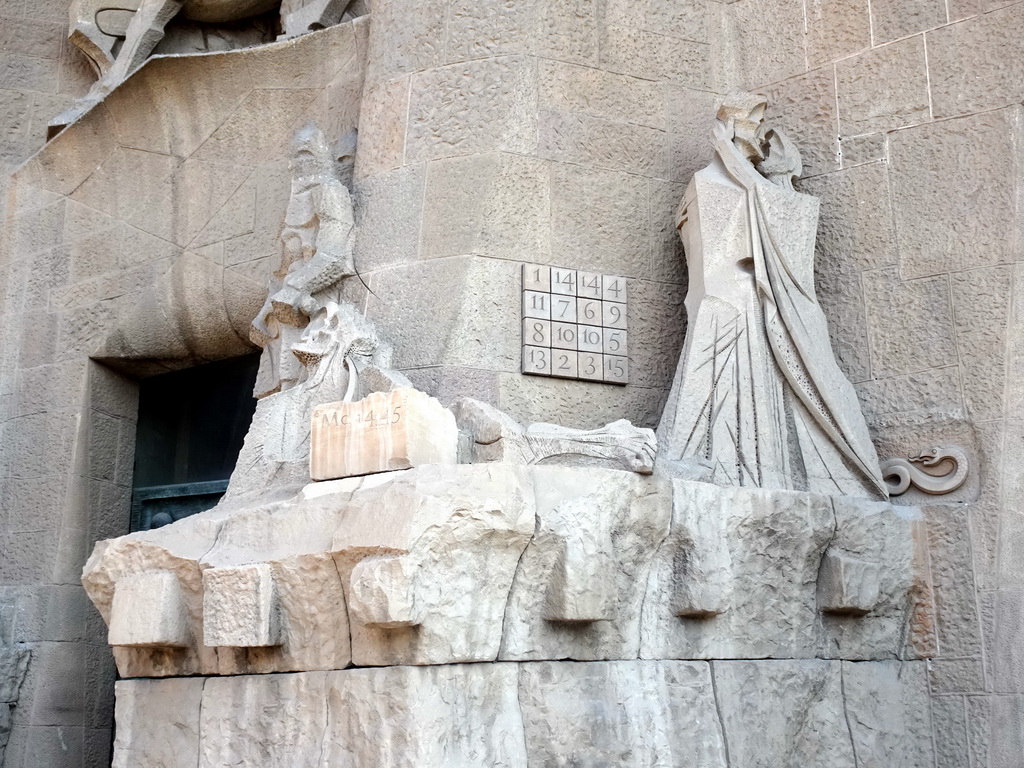 Statues and magic square at the left side of the Portico of the Passion Facade at the southwest side of the Sagrada Família church