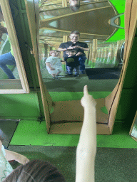 Tim, Max and Max`s friend in a distorting mirror at the Rainforest Mirror Maze attraction at the funfair at the Brigidastraat street