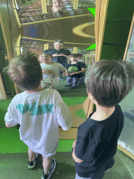 Tim, Max and Max`s friend with a distorting mirror at the Rainforest Mirror Maze attraction at the funfair at the Brigidastraat street