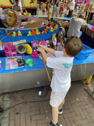 Max`s friend doing a fishing game at the funfair at the Jack van Gilsplein square