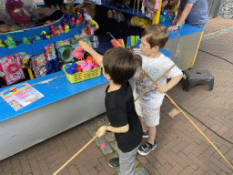 Max and his friend doing a fishing game at the funfair at the Jack van Gilsplein square