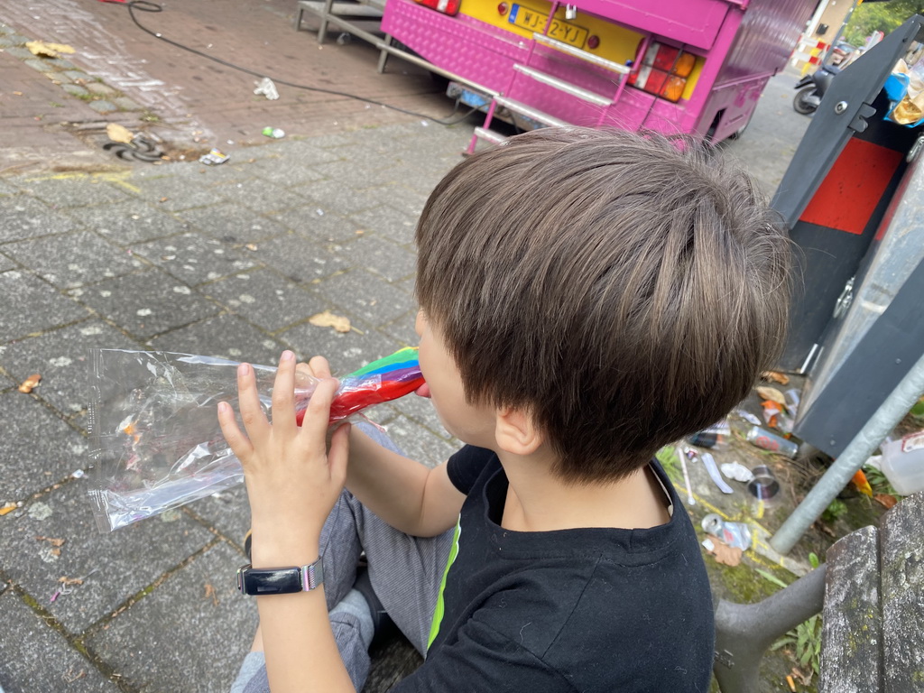 Max with a lollipop on a bench at the funfair at the Jack van Gilsplein square