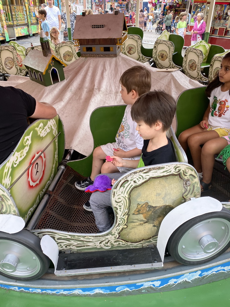 Max and his friend at a carousel at the funfair at the Brigidastraat street