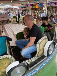 Max and his friend with a plume at a carousel at the funfair at the Brigidastraat street