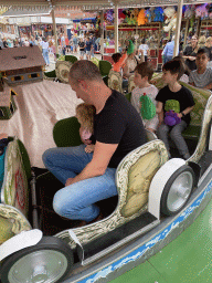 Max and his friend with a plume at a carousel at the funfair at the Brigidastraat street