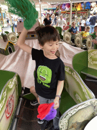 Max and his friend with a plume at a carousel at the funfair at the Brigidastraat street