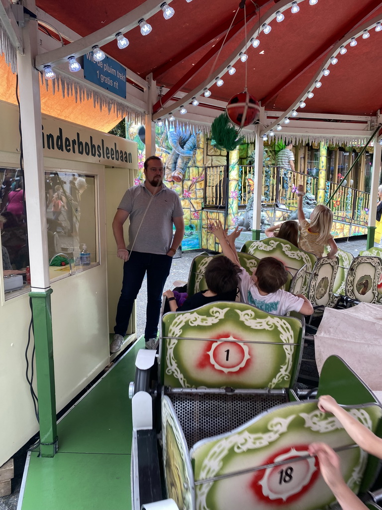 Max and his friend grabbing a plume at a carousel at the funfair at the Brigidastraat street