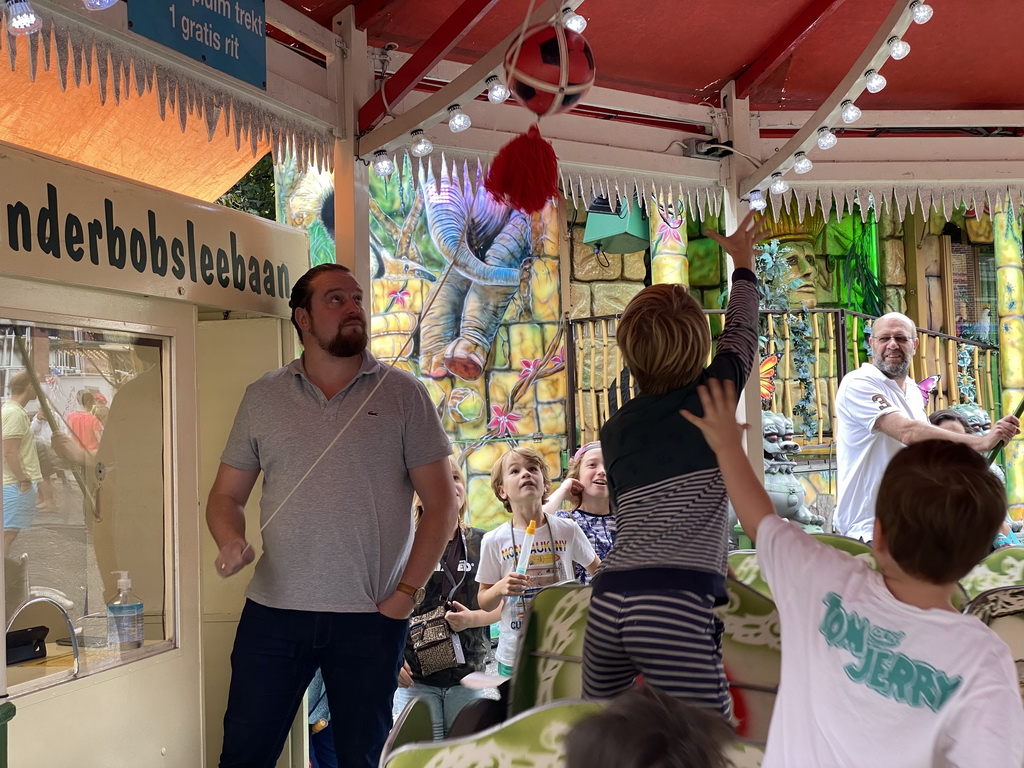 Max and his friend grabbing a plume at a carousel at the funfair at the Brigidastraat street