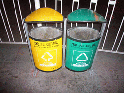 Trash cans with Chinglish explanation, by night
