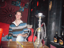 Tim with a drink, a shisha and a cat in a pub at Beihai Lake