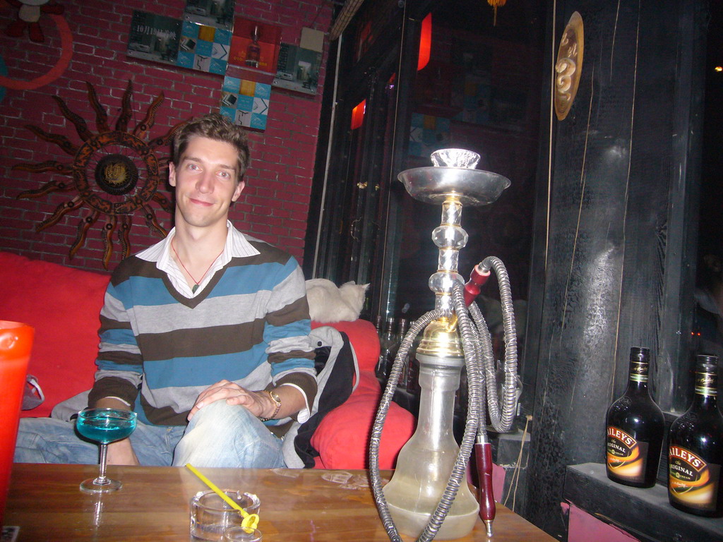 Tim with a drink, a shisha and a cat in a pub at Beihai Lake