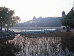 Boats at the east side of Kunming Lake and Longevity Hill with the Tower of Buddhist Incense and the Hall of the Sea of Wisdom at the Summer Palace, viewed from the East Causeway, at sunset