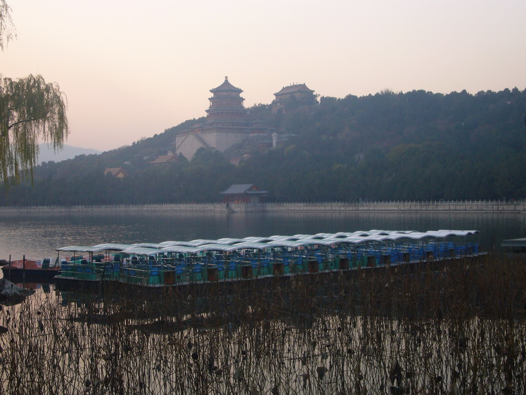 Boats at the east side of Kunming Lake and Longevity Hill with the Tower of Buddhist Incense and the Hall of the Sea of Wisdom at the Summer Palace, viewed from the East Causeway, at sunset