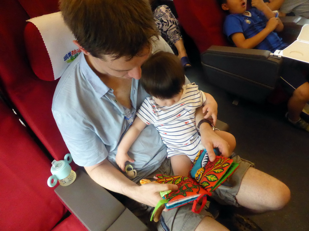 Tim and Max reading a book in the high speed train to Zhengzhou