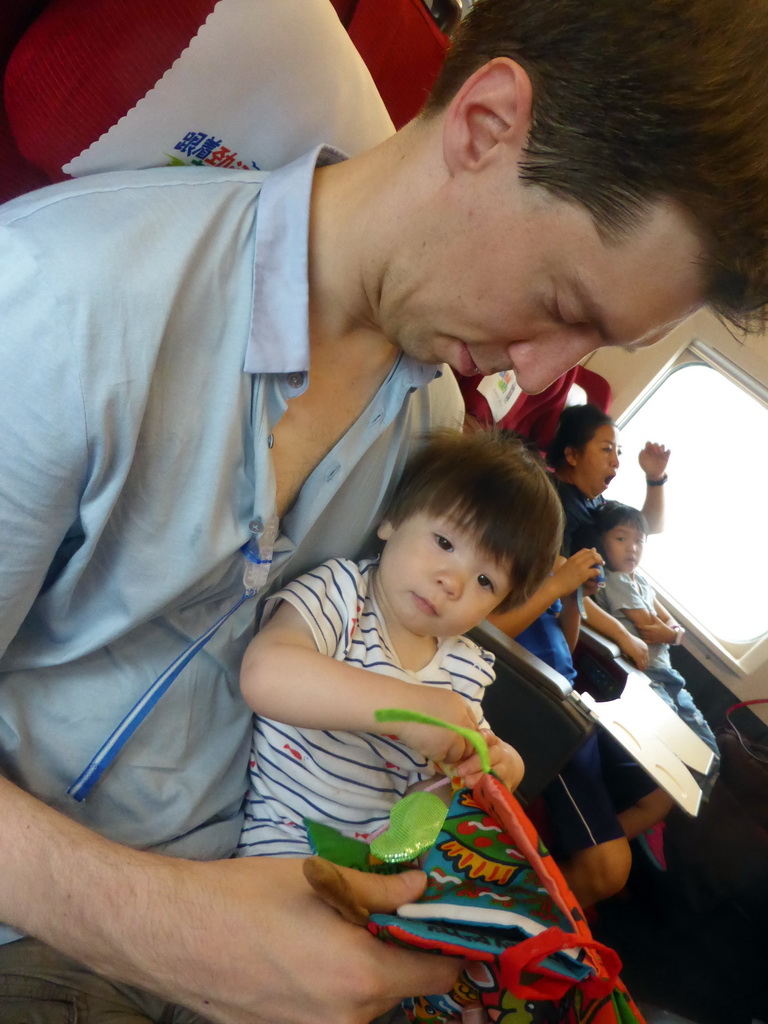 Tim and Max reading a book in the high speed train to Zhengzhou