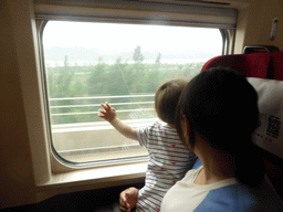 Miaomiao and Max looking out of the window of the high speed train to Zhengzhou
