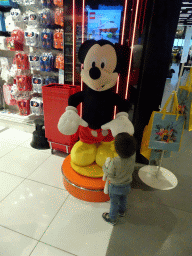 Max with a Mickey Mouse doll in front of a shop at the Departures Hall of Schiphol Airport