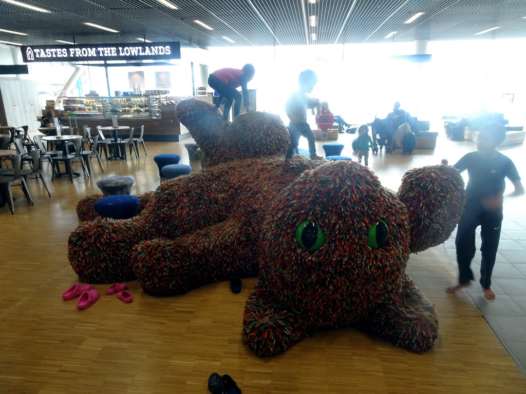 Max on top of a cat statue at the Departures Hall of Schiphol Airport