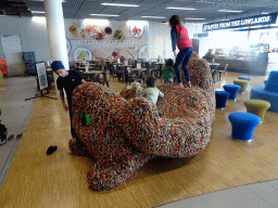 Max on top of a cat statue at the Departures Hall of Schiphol Airport