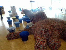 Max on top of a cat statue at the Departures Hall of Schiphol Airport