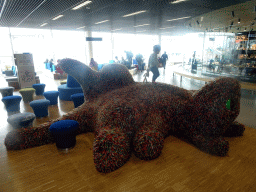 Max on top of a cat statue at the Departures Hall of Schiphol Airport