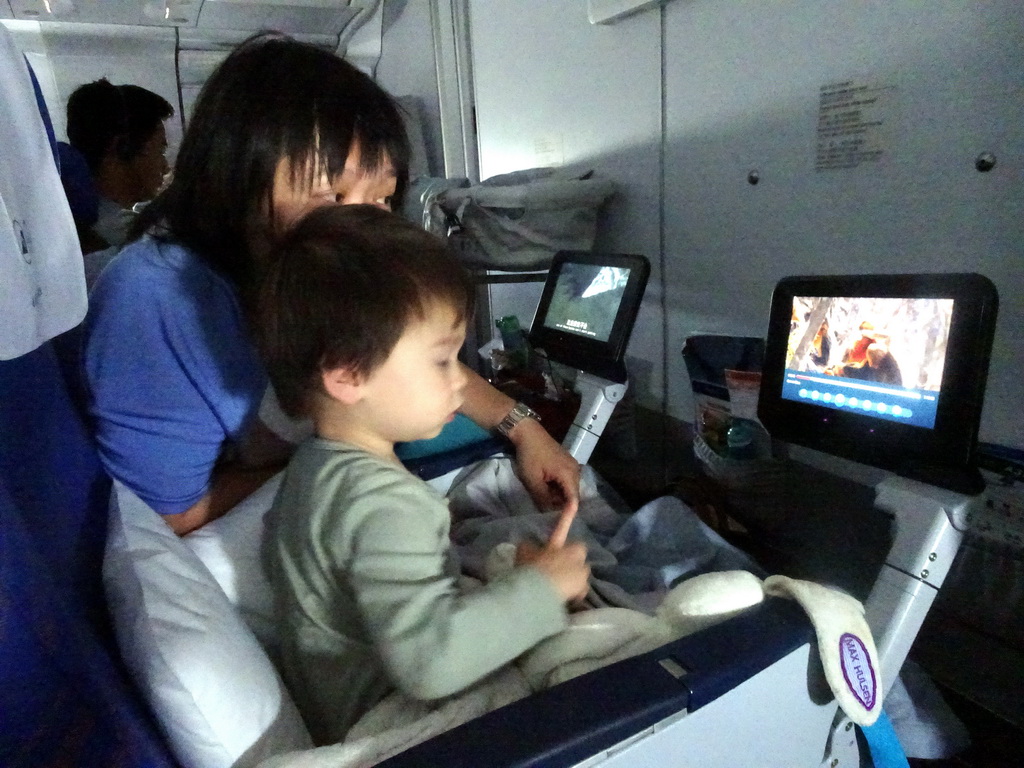 Miaomiao and Max watching television in the airplane from Amsterdam