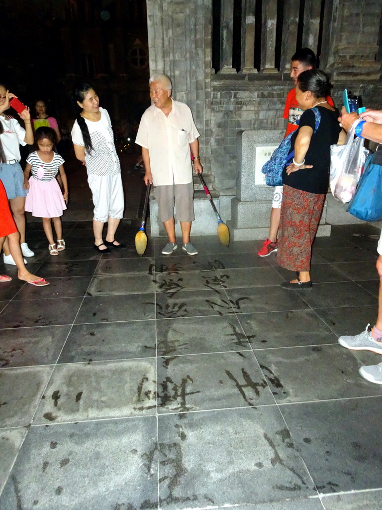 Calligraphy artist in front of St. Joseph`s Wangfujing Church at Wangfujing Street, by night