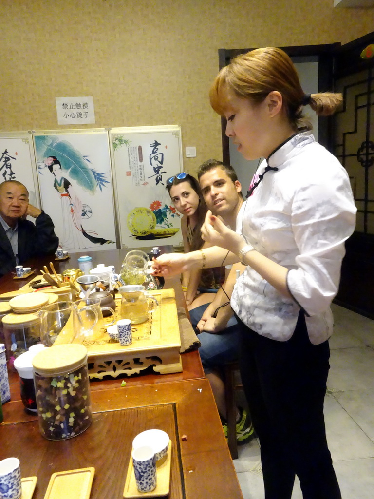 Person explaining the tea making process in a tea house at Heiquan Road