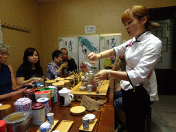 Person explaining the tea making process in a tea house at Heiquan Road