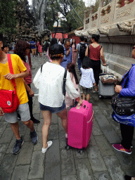 Tourists with big suitcases at the back side of the Imperial Garden of the Forbidden City