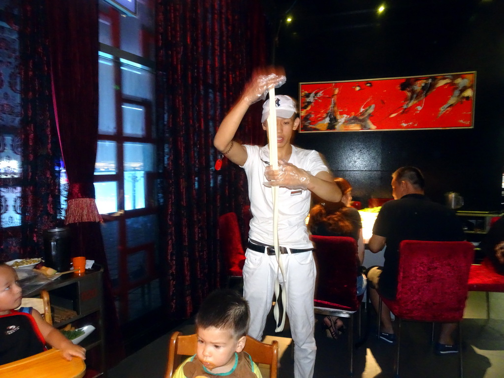 Max and a man making noodles in a restaurant at the Intime Lotte department store