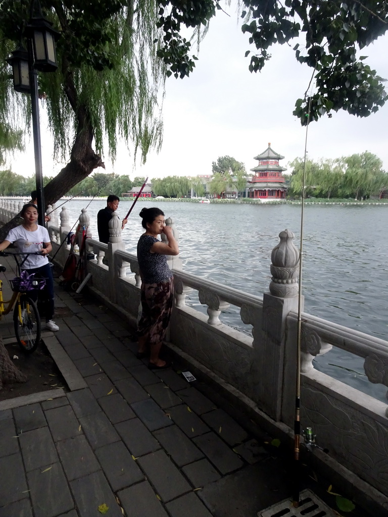 Fishermen at the Houhai Nanyan street, with a view on Houhai Lake and the pavilion at the Houhai Beiyan street