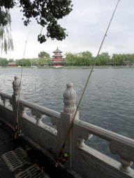 Fishing poles at the Houhai Nanyan street, with a view on Houhai Lake and the pavilion at the Houhai Beiyan street