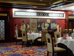 Dinner tables and paintings at the restaurant at the first floor of the Beijing Prime Hotel Wanfujing