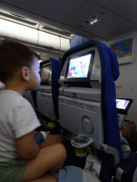 Max watching television in the airplane to Amsterdam