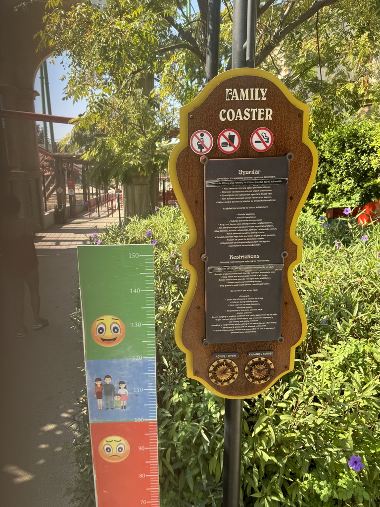 Miaomiao and a sign in front of the Family Coaster attraction at the Adventure Land area of the Land of Legends theme park