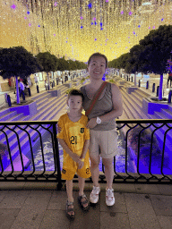 Miaomiao and Max on a bridge over the canal at the Shopping Avenue area of the Land of Legends theme park, by night