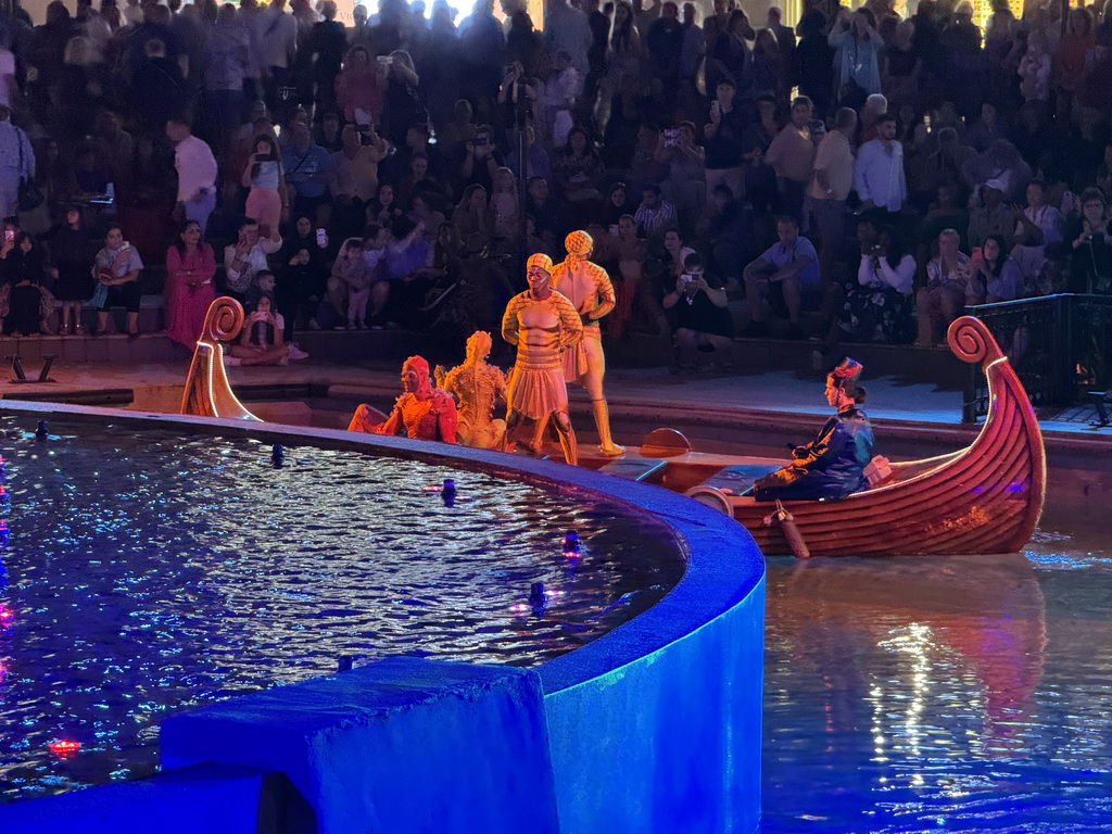 Boat with actors behind of the Chimera Fountain at the Shopping Avenue area of the Land of Legends theme park, during the Musical Boat Parade, by night